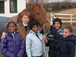 Five people standing in front of a horse.