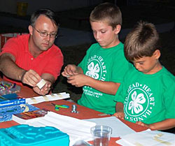 Two 4-H'ers and an adult workign on a science experiment.